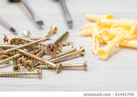 Screws and screwdrivers on gray wooden background 81483709