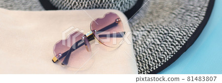 Women hat and sunglasses lie on deck chair Women hat and sunglasses lie on deck chair 81483807