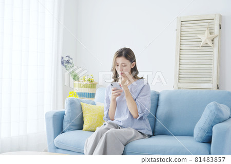 A woman thinking with a smartphone A woman thinking with a smartphone 81483857
