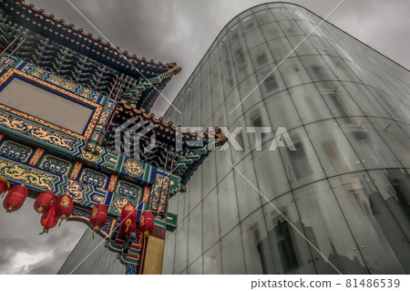 Contrast of modern glass building with Chinatown entrance gate in traditional chinese design. 81486539