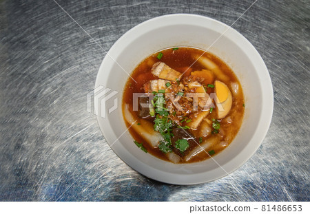 Chinese roll noodle soup with Crispy pork, Boiled egg, Pork blood Served on white bowl. Thai language called (Kuay Jab). Chinese roll noodle soup with Crispy pork, Boiled egg, Pork blood Served on white bowl. Thai language called (Kuay Jab). 81486653