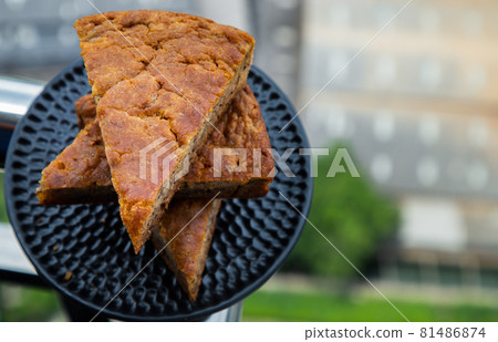 Homemade tasty banana cake slices on Black ceramic plate with city view. Homemade tasty banana cake slices on Black ceramic plate with city view. 81486874
