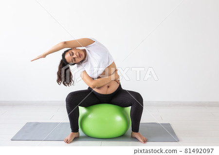 beautiful young pregnant woman doing exercise at home on fitball beautiful young pregnant woman doing exercise at home on fitball 81492097