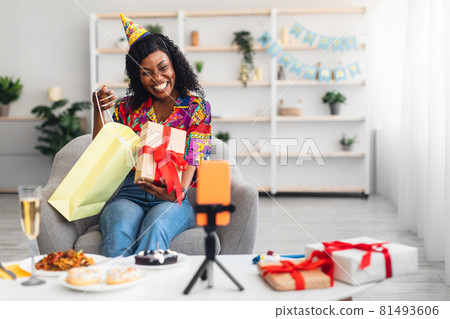 Black Lady Opening Birthday Present Near Phone Having Party Indoor Black Lady Opening Birthday Present Near Phone Having Party Indoor 81493606