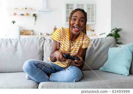 Joyful black woman playing video games at home 81493999