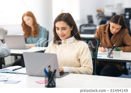 Portrait of female student using laptop in classroom Portrait of female student using laptop in classroom 81494149