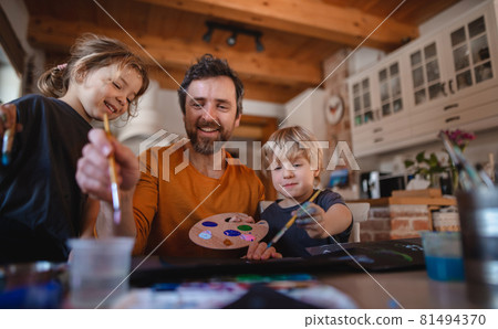 Mature father with two small children resting indoors at home, painting pictures. Mature father with two small children resting indoors at home, painting pictures. 81494370