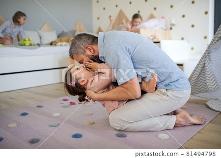 Father with daughters indoors at home, playing, laughing and having fun. 81494798