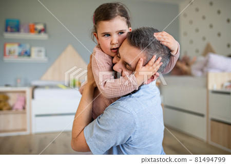 Happy father with daughter indoors at home, hugging. 81494799