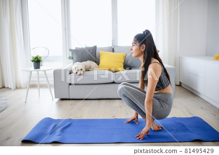 Portrait of young sport woman doing exercise indoors at home, healthy lifestyle concept. Portrait of young sport woman doing exercise indoors at home, healthy lifestyle concept. 81495429