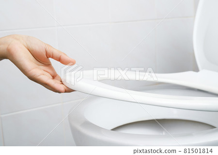 Woman's hand opening the toilet lid 81501814
