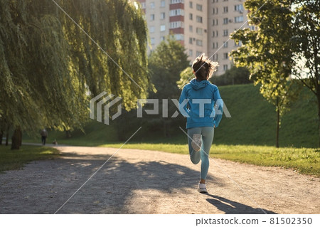 Young athletic woman jogging on the road in the morning 81502350