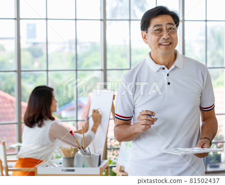 Senior man and woman couple, husband and wife, painting image together in home gallery with warm and happy circumstance. Idea for time-sharing and relaxing for older people after retirement Senior man and woman couple, husband and wife, painting image together in home gallery with warm and happy circumstance. Idea for time-sharing and relaxing for older people after retirement 81502437