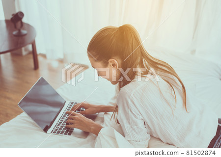Happy woman typing keyboard and using laptop on bed,Online shopping concept 81502874