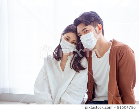 亞洲年輕女性和亞洲年輕男性在家戴外科口罩防止隔離感染新冠肺炎或流感 81504786