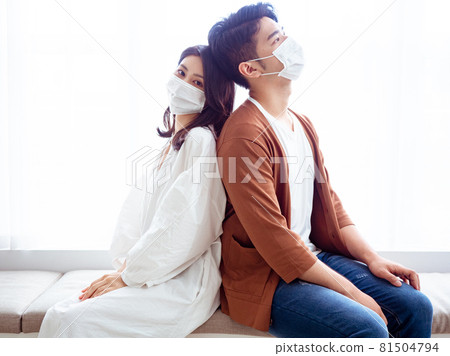 Young Asian women and young Asian men wearing surgical masks at home to prevent coronavirus or flu infection in isolation 81504794