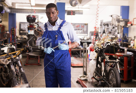 Service engineer repairing motorcycle in motorcycle service 81505183