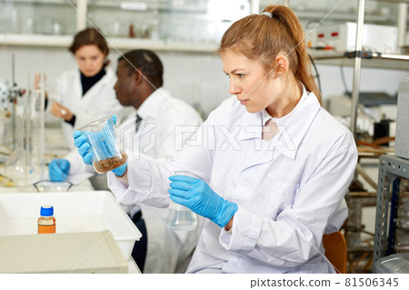Young woman scientist working in research laboratory performing experiments 81506345