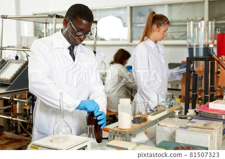Focused man lab technician in glasses working with reagents and test tubes Focused man lab technician in glasses working with reagents and test tubes 81507323