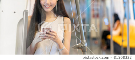 Banner, web page or cover template of Young Asian woman passenger using and listening music via smart mobile phone in subway train station, japanese,chinese,Korean lifestyle, leisure and daily life, 81508322