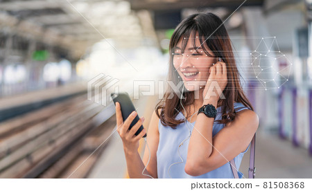 Asian woman using face recognition via smart mobile phone and listening the music at Railroad Station Platform, Biometric Verification and artificial intelligence concept Asian woman using face recognition via smart mobile phone and listening the music at Railroad Station Platform, Biometric Verification and artificial intelligence concept 81508368