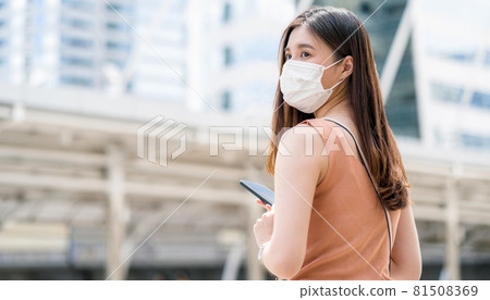 Young Asian woman using smart mobile phone in outside big city at Covid19 outbreak, Infection and Pandemic, commuter and transportation, social distancing and new normal concept Young Asian woman using smart mobile phone in outside big city at Covid19 outbreak, Infection and Pandemic, commuter and transportation, social distancing and new normal concept 81508369