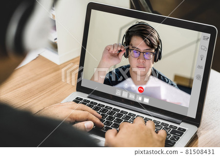 Asian business man wearing headphone and using laptop for video conference with colleague to online meeting when Coronavirus outbreak, Covid-19 pandemic, Social distancing and new normal concept Asian business man wearing headphone and using laptop for video conference with colleague to online meeting when Coronavirus outbreak, Covid-19 pandemic, Social distancing and new normal concept 81508431