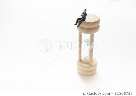 Office worker riding an hourglass (miniature) 81508725