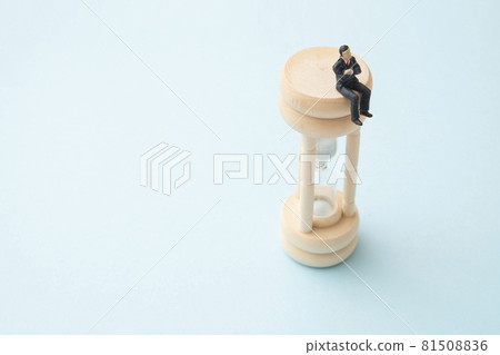 Office worker riding an hourglass (miniature) 81508836
