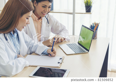 Two asian women doctors discuss meeting doctor's office medical clinic using laptop consulting patient disease. Asian medical lab young women talking together discussing healthcare assistance teamwork Two asian women doctors discuss meeting doctor's office medical clinic using laptop consulting patient disease. Asian medical lab young women talking together discussing healthcare assistance teamwork 81509852
