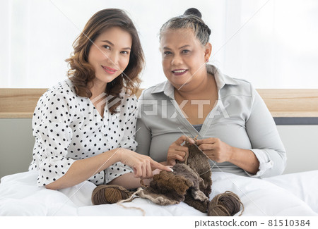 A middle aged daughter tri to teach older senior mother to make a dress with knitting handcraft work. Idea for family love and time sharing A middle aged daughter tri to teach older senior mother to make a dress with knitting handcraft work. Idea for family love and time sharing 81510384