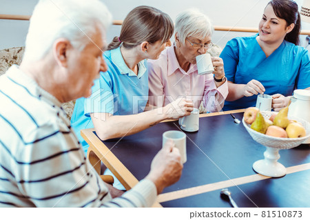 Seniors and caregivers having coffee time in the nursing home Seniors and caregivers having coffee time in the nursing home 81510873