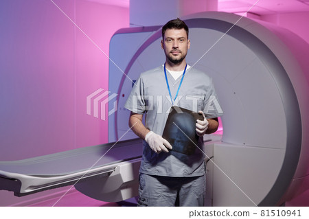 Young successful radiologist with x-ray image standing by workplace Young successful radiologist with x-ray image standing by workplace 81510941