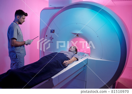 Young patient covered with towel lying on mri scan machine table Young patient covered with towel lying on mri scan machine table 81510970