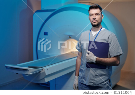 Young serious clinician in uniform and gloves Young serious clinician in uniform and gloves 81511064
