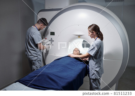 Young assistant preparing little girl for mri scan examination Young assistant preparing little girl for mri scan examination 81511233
