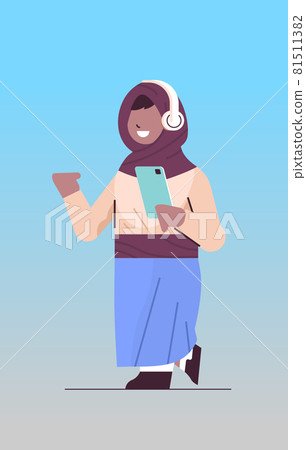arab schoolgirl using smartphone and listening to music in headphones arabic girl with gadget vertical arab schoolgirl using smartphone and listening to music in headphones arabic girl with gadget vertical 81511382