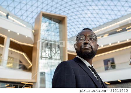 Young serious African businessman looking forwards against modern architecture 81511420