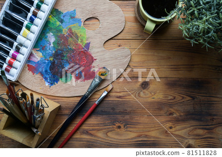 Paint brushes, watercolors and palette on wooden table. Creative workspace. Paint brushes, watercolors and palette on wooden table. Creative workspace. 81511828