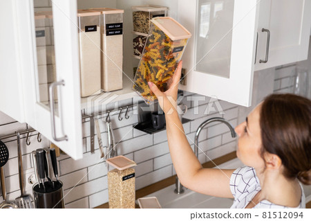 Laughing young female housewife posing during general cleaning, tidying up in cupboard kitchen Laughing young female housewife posing during general cleaning, tidying up in cupboard kitchen 81512094