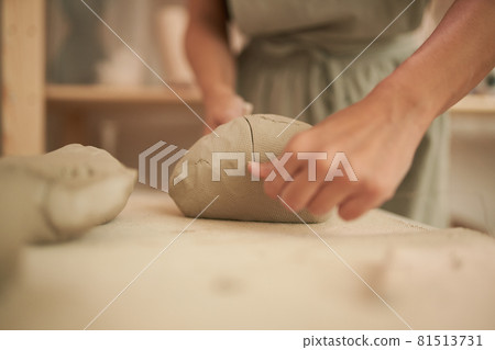 Unrecognizable female artisan dividing clay Unrecognizable female artisan dividing clay 81513731