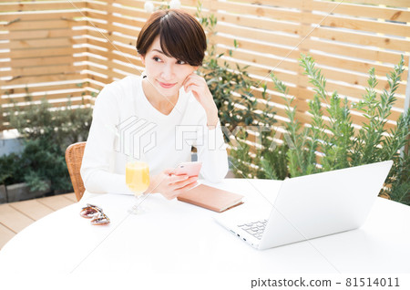 A woman operating a smartphone while working outdoors A woman operating a smartphone while working outdoors 81514011