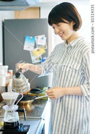 A woman who is making coffee 81514335