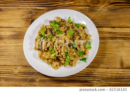 Tasty risotto with mushrooms on wooden table. Top view 81516183