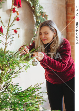 Female decorating Christmas tree at home 81516939