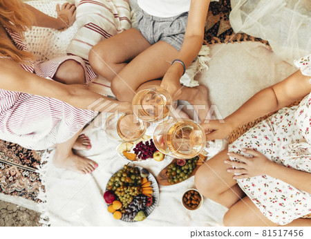 Crop women drinking wine during picnic Crop women drinking wine during picnic 81517456