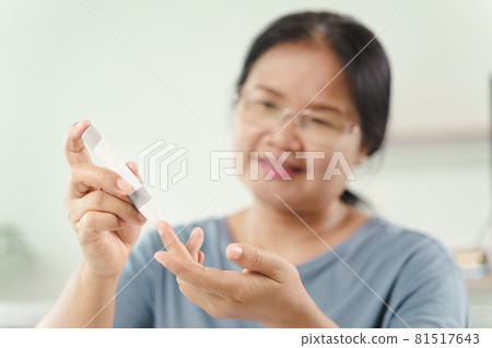 Asian woman using lancet on finger for checking blood sugar level by Glucose meter, Healthcare and Medical, diabetes, glycemia concept Asian woman using lancet on finger for checking blood sugar level by Glucose meter, Healthcare and Medical, diabetes, glycemia concept 81517643