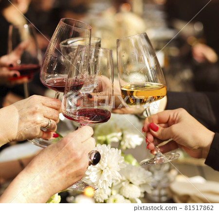 Friends toasting with wine during dinner Friends toasting with wine during dinner 81517862