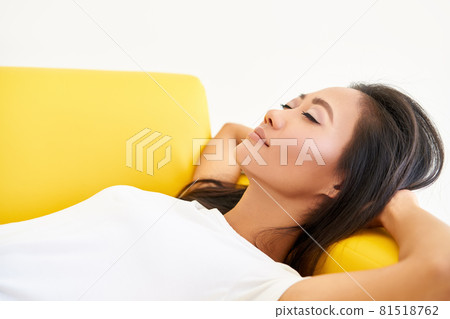 Young pretty woman closed her eyes lying on yellow sofa and relaxing after busy day Young pretty woman closed her eyes lying on yellow sofa and relaxing after busy day 81518762
