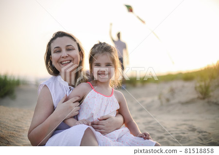 Happy family with parents and kids playing together with snakes on a beach vacation 81518858